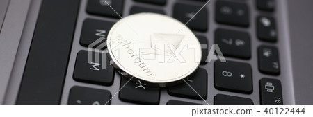 Silver ethereum coin is lying on laptop Silver ethereum coin is lying on laptop 40122444