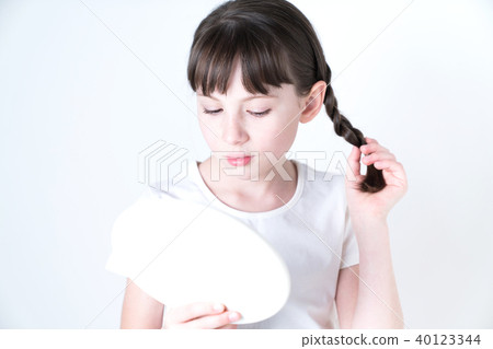 A girl watching a hand mirror A girl watching a hand mirror 40123344