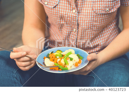 The girl holds a plate with vegetables 40123723