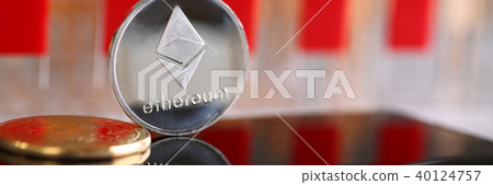 Silver ethereum coin is lying on cellphone Silver ethereum coin is lying on cellphone 40124757