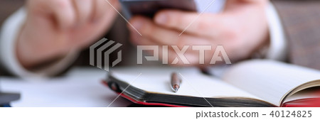 Male arm in suit hold phone and silver pen Male arm in suit hold phone and silver pen 40124825