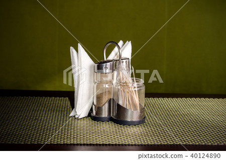Pepper shaker, salt shaker and napkins on the stand 40124890