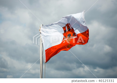 close up of Gibraltar flag waving against blue sky close up of Gibraltar flag waving against blue sky 40125331