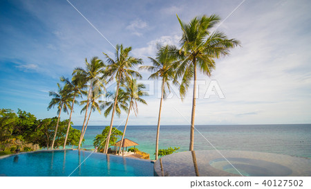 Outdoor swimming pool in a tropical country Philippines with palm trees. Evening time 40127502