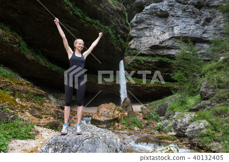 Active woman raising arms inhaling fresh air, feeling relaxed in nature. Active woman raising arms inhaling fresh air, feeling relaxed in nature. 40132405