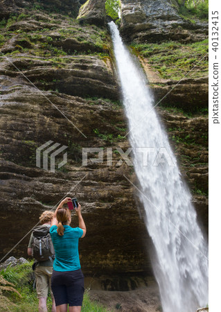 Active tourists looking at Pericnik waterfall in Vrata Valley in Triglav National Park in Julian 40132415