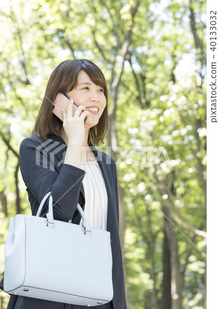 20-year-old woman who talks by cell phone, refreshing image of fresh green 20-year-old woman who talks by cell phone, refreshing image of fresh green 40133032