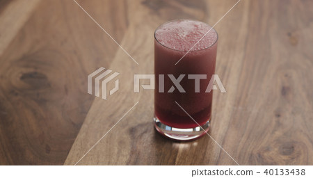 closeup red berry drink in a glass on wood table closeup red berry drink in a glass on wood table 40133438