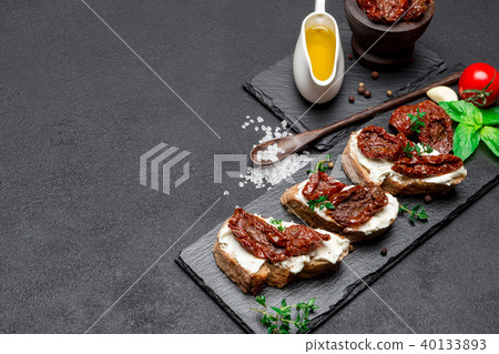 bruschetta with Canned Sundried or dried tomato halves on stone serving board 40133893