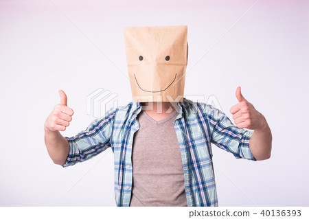 Unknown man showing thumbs up with a paper bag on his head on white background Unknown man showing thumbs up with a paper bag on his head on white background 40136393