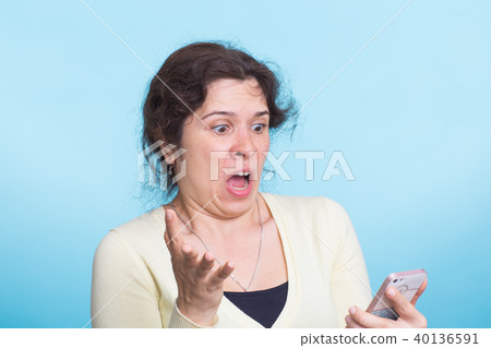 Angry aggressive woman on blue background Angry aggressive woman on blue background 40136591