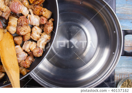 Chef putting cooked streaky pork to pot 40137182