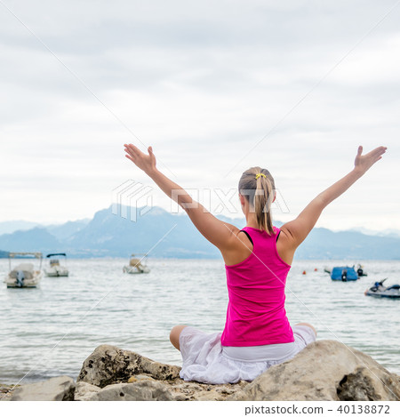 Woman meditating at the lake 40138872