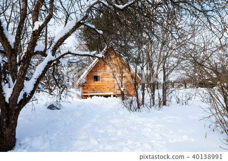 little timber cottage in snow-covered garden 40138991