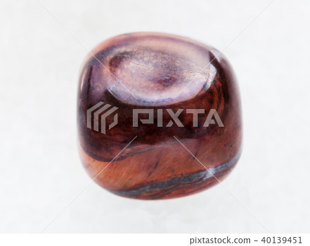 tumbled jaspilite gem stone on white marble 40139451