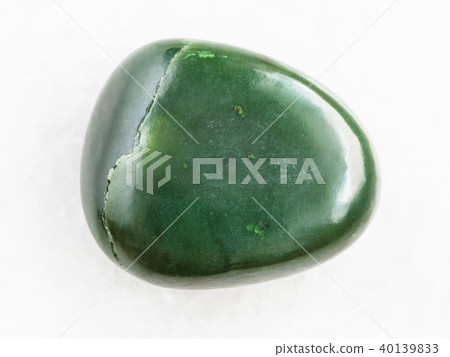 tumbled green nephrite gemstone on white marble tumbled green nephrite gemstone on white marble 40139833