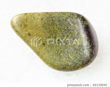 tumbled epidote gemstone on white marble 40139842