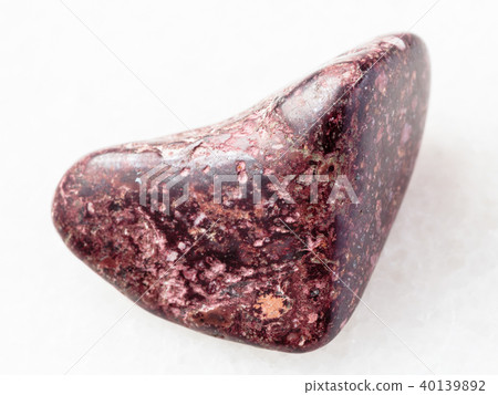 tumbled Piemontite gemstone on white 40139892