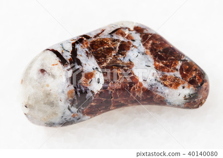tumbled Eudialyte in syenite stone on white tumbled Eudialyte in syenite stone on white 40140080