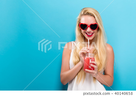 Happy young woman drinking smoothie Happy young woman drinking smoothie 40140658