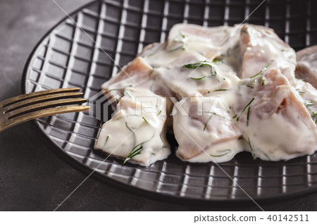 Pickled herring in cream sauce with dill. 40142511
