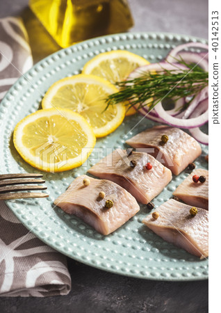 Pickled herring with red onion and lemon slices. Pickled herring with red onion and lemon slices. 40142513