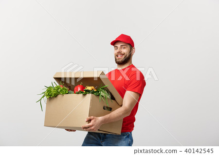 Delivery Concept - Handsome Cacasian delivery man carrying package box of grocery food and drink 40142545