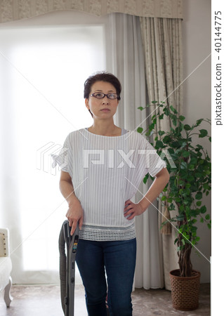Middle-aged woman vacuuming 40144775