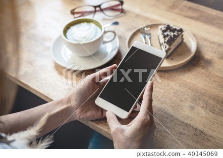 Young woman using smart phone in coffee shop Young woman using smart phone in coffee shop 40145069