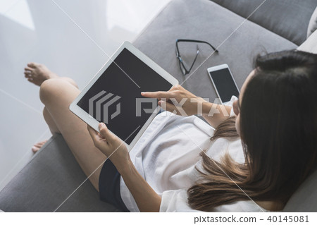 Young asian woman using tablet at home Young asian woman using tablet at home 40145081