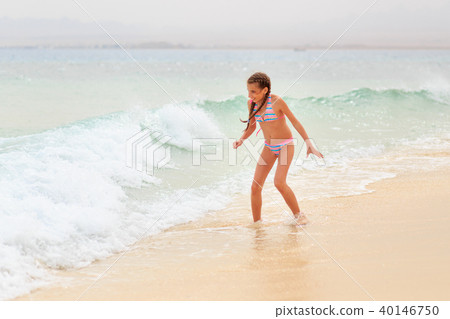 Young teenage girl having fun with waves on beach 40146750
