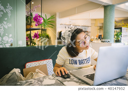 Woman using laptop while sitting at cafe. Woman using laptop while sitting at cafe. 40147932
