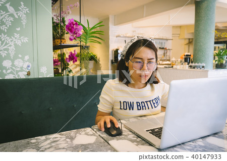 Woman using laptop while sitting at cafe. Woman using laptop while sitting at cafe. 40147933