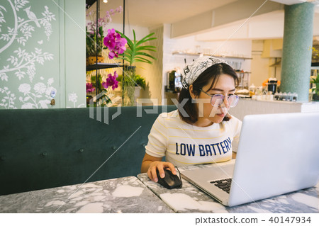 Woman using laptop while sitting at cafe. Woman using laptop while sitting at cafe. 40147934