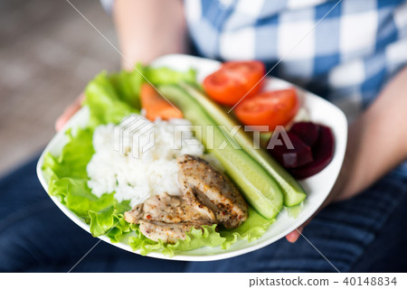Girl with a plate of vegetables in hands 40148834