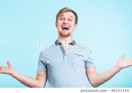Excited man exclaimed in happiness, gestures actively, expressed great surprisement, over blue 40153159