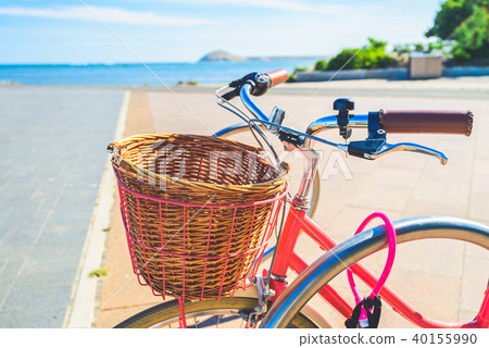 Pink vintage bicycle with basket on steering wheel 40155990