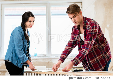 Young couple sharing tools while working on improvement of their house 40158653