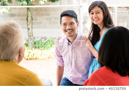 Rear view of elderly couple visited by their son or daughter 40158709