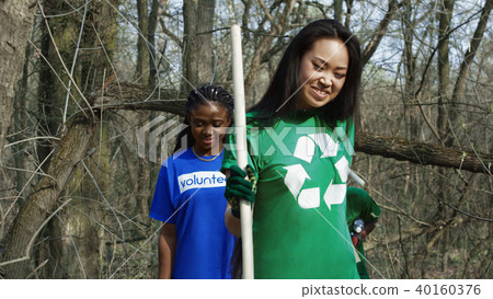 Diverse volunteers walking in forest 40160376