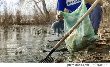 Crop people cleaning up water of pond 40160386