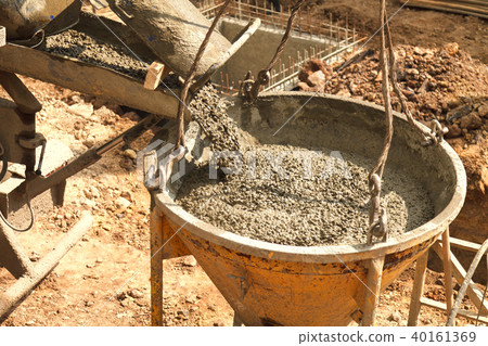 Pouring concrete into the construction of the hous 40161369
