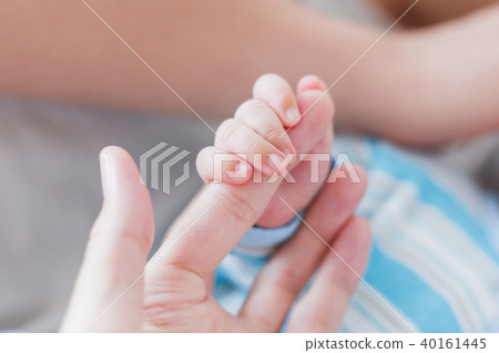 Newborn baby holding his mother finger.  40161445