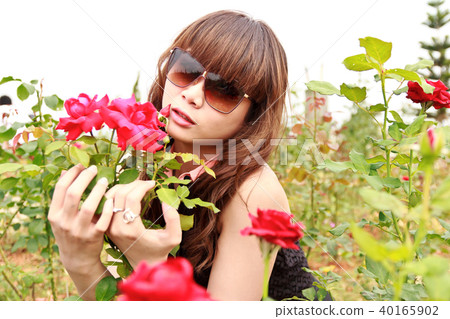 Woman in garden with roses Woman in garden with roses 40165902