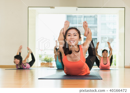 Yoga class,Group of people doing bow poses Yoga class,Group of people doing bow poses 40166472