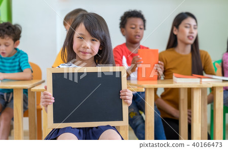 Kid girl holding blackboard with diversity friends Kid girl holding blackboard with diversity friends 40166473