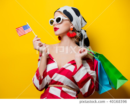 Woman with US flag and shopping bags Woman with US flag and shopping bags 40168396