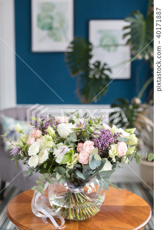 Sunny spring morning in living room. Beautiful luxury bouquet of mixed flowers in glass vase on Sunny spring morning in living room. Beautiful luxury bouquet of mixed flowers in glass vase on 40171887