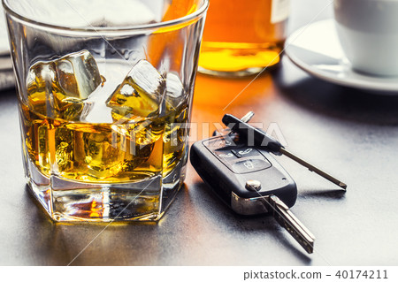 Car keys and glass of alcohol on table. Car keys and glass of alcohol on table. 40174211