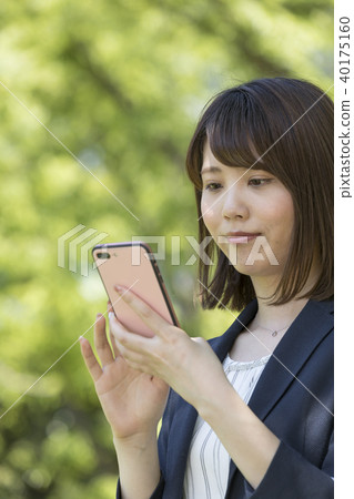 A woman in her 20s who operates a smartphone, fresh green image A woman in her 20s who operates a smartphone, fresh green image 40175160